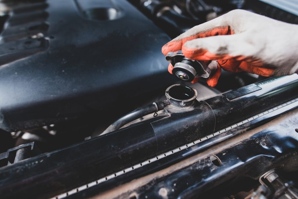 Mechanic in Memphis Checking Coolant on a car